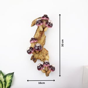 Pu&ograve; includere: Decorazione da parete in legno con diversi funghi decorativi. I funghi hanno cappelli bordeaux con pois bianchi e sono attaccati a un ramo di legno naturale, che misura 30 cm di altezza e 16 cm di larghezza.