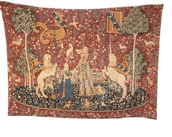 May include: A rectangular wall tapestry featuring a red background with a millefleur pattern. The scene depicts a central figure standing between a lion and a unicorn, each holding a banner. The design includes trees, small animals, and floral motifs.