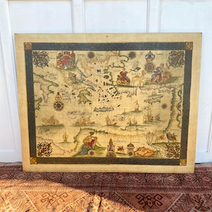 Peut inclure: Impression d'une carte du monde ancienne avec des illustrations détaillées de navires, de personnages et de bordures décoratives. La carte a un fond beige et une bordure bleu foncé, idéale pour la décoration intérieure.