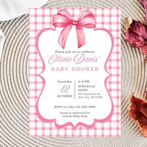 Puede incluir: Invitación rosa para baby shower con un fondo de cuadros vichy y un lazo rosa decorativo. La invitación incluye el texto "Olivia Davis BABY SHOWER" y detalles del evento. También se incluye información de RSVP.