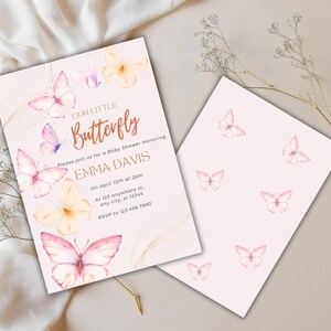 Op de afbeelding: Babyborrel uitnodiging met aquarel vlinders in roze, paars en geel. De uitnodiging luidt "Our Little Butterfly" en bevat evenementdetails. Er is ook een bijpassende kaart met een vlinderpatroon.