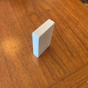 May include: A white wooden block on a wooden surface.