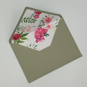 May include: A green envelope with a floral pattern on the inside flap. The pattern features pink and red flowers with green leaves on a white background.