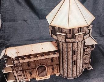 Könnte beinhalten: Ein Holzmodell einer mittelalterlichen Burg mit einem Turm und einem kleineren angebauten Gebäude. Das Modell ist aus hellem braunem Holz gefertigt und hat ein detailliertes Design.