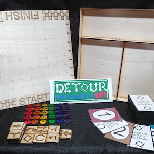 Pode incluir: Um tabuleiro de jogo de madeira com um padrão de grade e as palavras "FINISH" e "START" impressas nele. O tabuleiro de jogo faz parte de um jogo de tabuleiro chamado "Detour: The Game of Hope". O jogo inclui peças de jogo coloridas, cartas com números e instruções, e uma caixa de madeira.