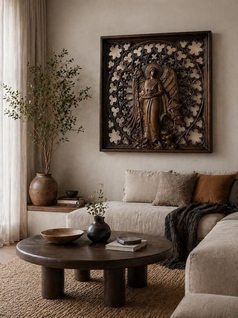 May include: A dark brown wooden angel wall art with intricate details hangs above a beige sofa. The angel is carved in a classical style, holding a staff. A round wooden coffee table and decorative vases complete the living room setting.