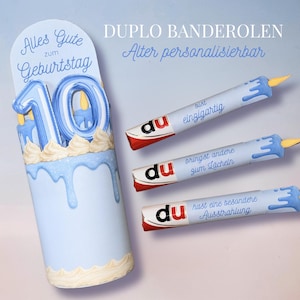 Puede incluir: Una caja de regalo cilíndrica de color azul claro con una ilustración de pastel, el número 10 y el texto Alles Gute zum Geburtstag, acompañada de tres barras de chocolate Duplo envueltas en papel azul a juego con texto en alemán.
