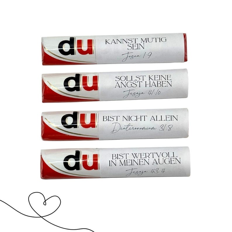May include: Four chocolate bars with white wrappers and red accents. Each bar has the word "du" printed on it, and a different German phrase with a Bible verse reference. A line drawing of a heart is in the lower left corner.