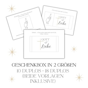 May include: Three white cards with gold and black text and line drawings. The cards read "GOTT ist Liebe" and feature a hand making a heart shape. The text "GESCHENKBOX IN 2 GR&Ouml;BEN" is at the bottom.