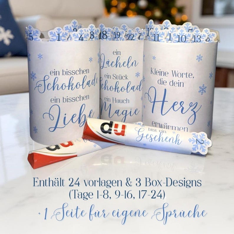 May include: Advent calendar with three white cylindrical containers decorated with blue snowflakes and text. The containers hold chocolate bars. The text includes phrases like "a little chocolate" and "a little love."