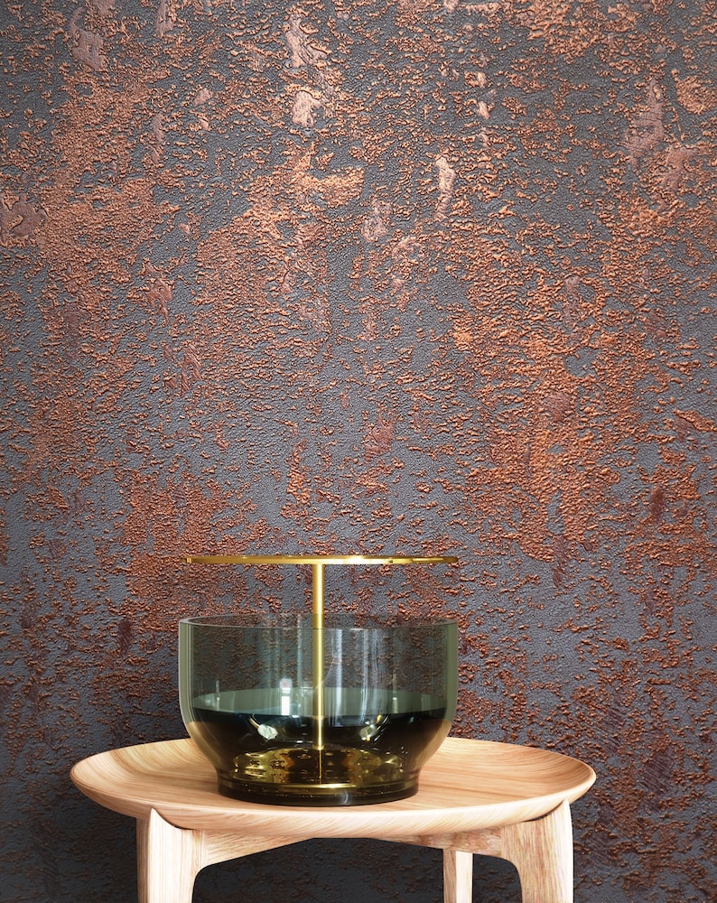 Peut inclure: Un vase en verre transparent avec un pi&eacute;destal en m&eacute;tal dor&eacute; et un dessus rond. Le vase est pos&eacute; sur une table en bois avec une surface textur&eacute;e. L'arri&egrave;re-plan est un mur textur&eacute; avec une finition cuivre.