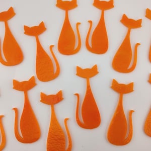 May include: Orange cat-shaped cutouts arranged on a white surface. The cat silhouettes have pointed ears, curved tails, and a textured appearance. The image features a repeating pattern of the cat shapes.