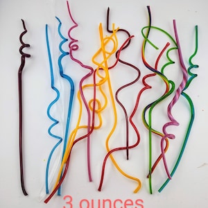 May include: A set of ten colorful glass drinking straws, each with a unique, wavy design. The straws are arranged in a fan shape on a white background. The text "3 ounces" is printed below the straws.