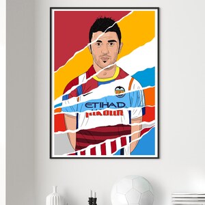 Op de afbeelding: Een digitale illustratie van een voetballer die een blauw en wit shirt draagt met de tekst "ETIHAD AIRWAYS" op de voorkant. Het shirt is gescheurd en gescheurd, waardoor een rood-wit gestreept shirt eronder zichtbaar wordt. De speler heeft kort bruin haar en een baard.