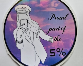 May include: A round sticker with a purple and pink cloudy background. A white outline of a person wearing a captain's hat and a jacket is taking a selfie. The text "Proud part of the 5%" is written in cursive.
