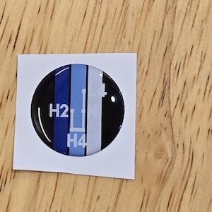 May include: A round sticker with a black, blue, and white design. The sticker has the text "H2" and "H4" on it.