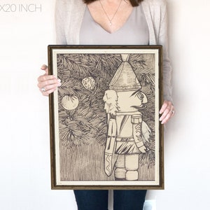 May include: A black and white illustration of a nutcracker standing in front of a Christmas tree. The nutcracker is wearing a hat and a uniform. The tree is decorated with ornaments.