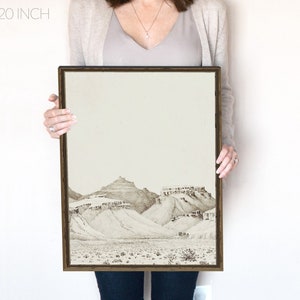 May include: A framed landscape art print featuring a desert scene with mountains and sparse vegetation. The artwork is in black and white, with the text "16x20 inch" in the upper left corner. The frame is dark brown.
