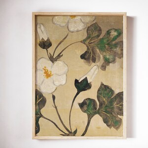 May include: A framed painting of white flowers with green leaves on a beige background. The flowers are stylized and have a yellow center. The leaves are a dark green with hints of gold.