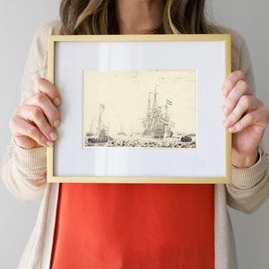 May include: A framed black and white drawing of a fleet of ships sailing on the water. The ships have sails and masts. The drawing is in a gold frame.
