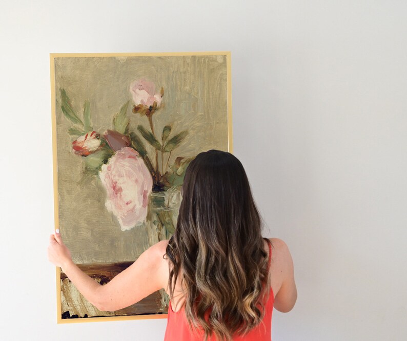 May include: A framed painting of a still life featuring pink peonies in a glass vase. The painting is on a light green background with a brown table.