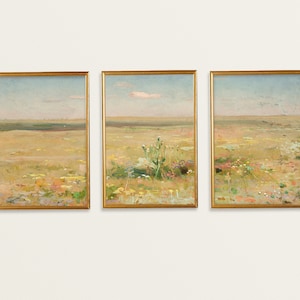 May include: A set of three framed landscape paintings depicting a field of wildflowers in shades of yellow, green, and pink under a blue sky with a few white clouds.