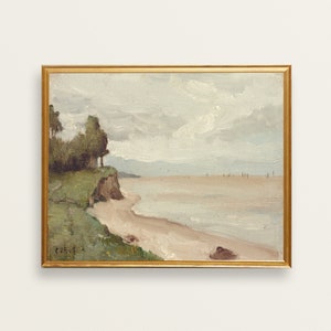 May include: A framed painting depicting a seascape with a sandy beach, a rocky cliff, and a line of trees in the foreground. The sky is cloudy and the water is calm. The painting is in a gold frame.