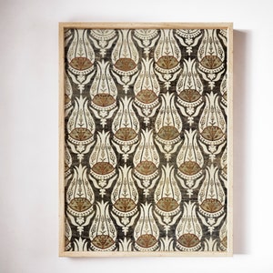 May include: A framed print of a vintage fabric with a repeating pattern of stylized white tulips on a dark gray background. The tulips have brown and orange accents.