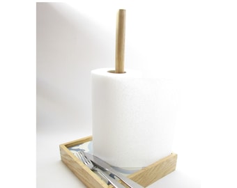 May include: Wooden countertop paper towel holder with a white paper towel roll and a small tray for utensils. The tray has a blue and white patterned tile design.
