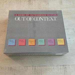 May include: A game box for the game "Out of Context", a game of outrageous quotes. The box is gray with a grid pattern and features six colorful sticky notes with quotes on them.