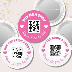 May include: Three round white and pink buttons with a QR code and the text "Buy me a shot before I tie the knot" or "Buy the bride a shot before she ties the knot".