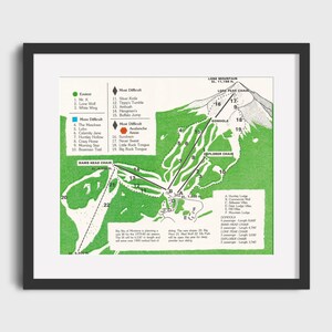 May include: A vintage ski map of Lone Mountain, showing the ski runs and lifts. The map is green and white with black text. The text includes the names of the ski runs, the lifts, and the elevation of the mountain. The map is framed in black.
