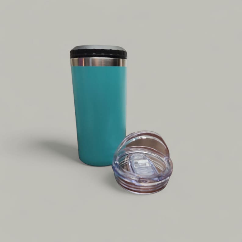 May include: A teal insulated tumbler with a black lid and a silver rim. The clear plastic lid is detached and placed next to the tumbler. The tumbler is designed to keep beverages hot or cold.