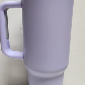 May include: A lavender travel mug with a white lid and a handle. The mug has a metallic iridescent band around the top.