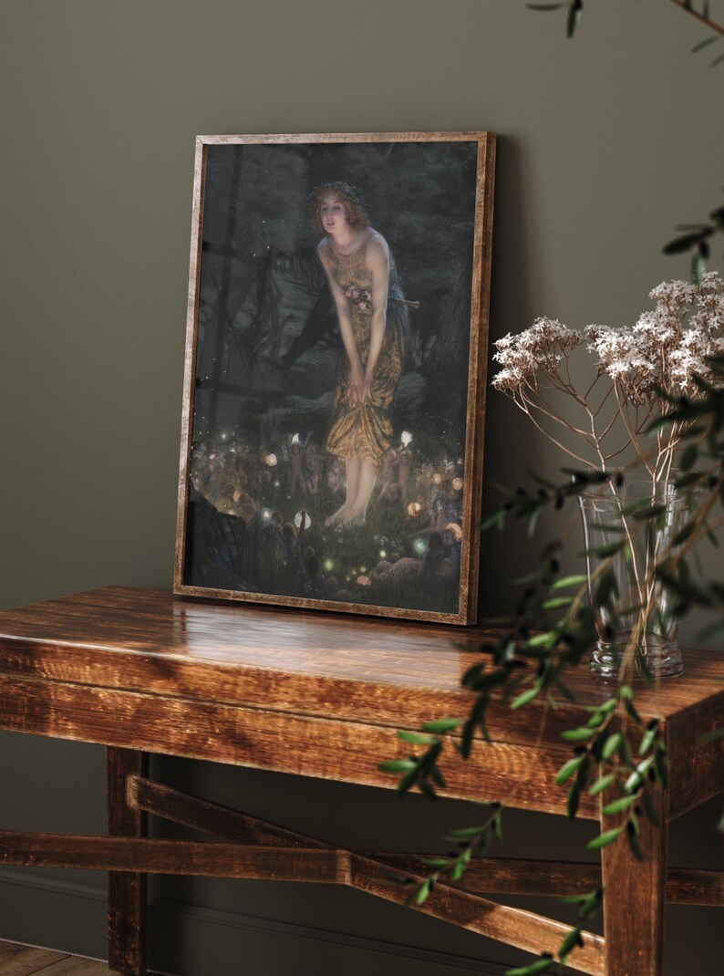 Op de afbeelding: Een ingelijst schilderij van een vrouw in een bosrijke omgeving. De vrouw draagt een lange, vloeiende jurk en een kroon van bloemen. Ze wordt omringd door kleine, gloeiende lichtjes.