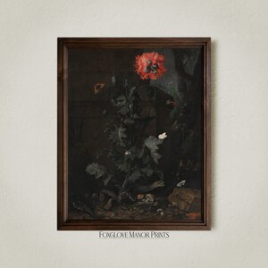 May include: A framed print of a still life painting featuring a red poppy flower with green leaves and stems. The background is dark and includes a stone wall and other foliage. The print is framed in a dark wood frame.