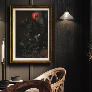 May include: A dark wood dining room with a framed botanical print of a red poppy and other flowers. The print is hanging on a dark wood wall. There is a black metal candle holder with white candles on the table. There is a wooden chair with a carved back and a wooden table with a black bowl on it.
