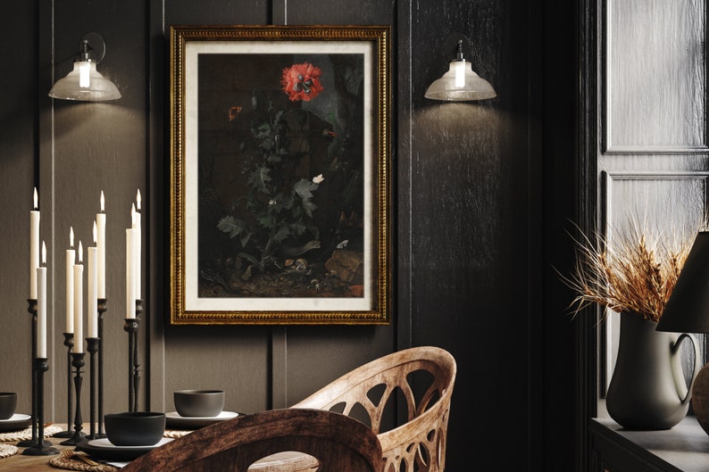 May include: A dark wood dining room with a framed botanical print of a red poppy and other flowers. The print is hanging on a dark wood wall. There is a black metal candle holder with white candles on the table. There is a wooden chair with a carved back and a wooden table with a black bowl on it.