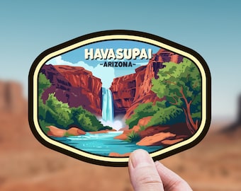 May include: A vintage-style sticker featuring a scenic view of Havasupai Falls in Arizona. The sticker depicts a waterfall cascading down a red rock canyon with lush green trees and a blue pool of water at the bottom. The text "HAVASUPAI -ARIZONA- " is displayed at the top of the sticker.
