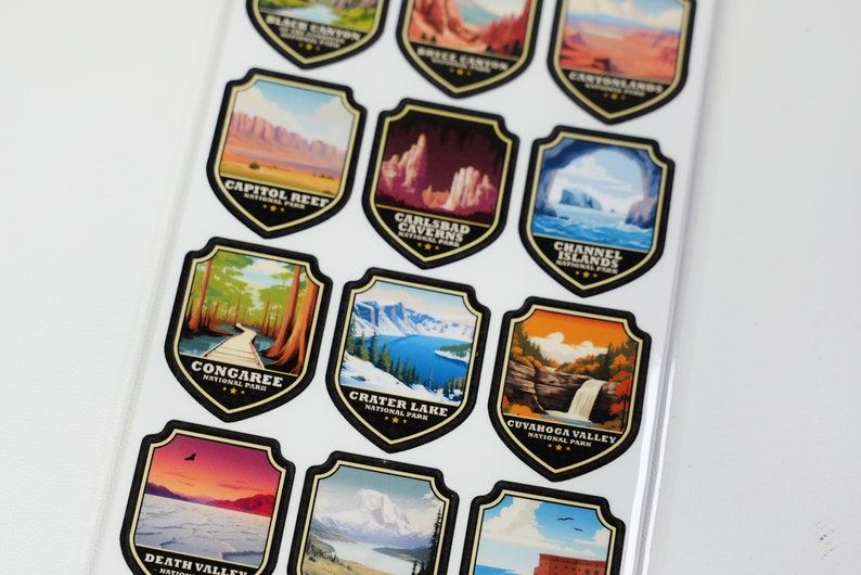 May include: A set of 12 colorful stickers featuring national parks in the United States. Each sticker is shaped like a shield and features a different park's name and a scenic image of the park. The stickers are perfect for adding a touch of nature to your belongings.