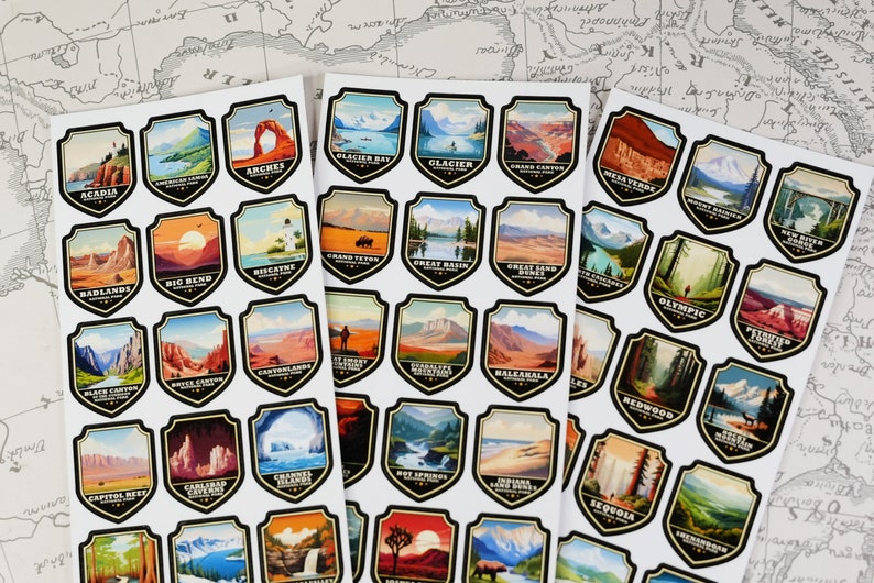 May include: A set of 48 stickers featuring colorful illustrations of national parks in the United States. Each sticker is shaped like a shield and features the name of the park and a scenic image. The stickers are printed on white paper.