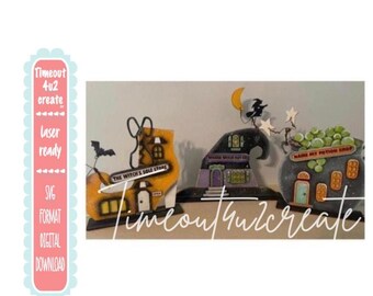May include: Three decorative Halloween-themed wooden cutouts featuring a yellow shoe-shaped building labeled The Witch's Sole Store, a purple hat-shaped building, and a gray cauldron-shaped building labeled Name My Potion Shop with green bubbles.