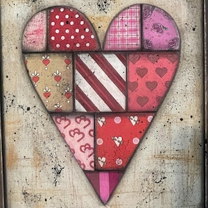 Peut inclure: Une œuvre d'art en forme de cœur composée de carreaux à motifs variés en rouge, rose et beige. Les carreaux présentent des pois, des rayures, des cœurs et des motifs floraux. L'œuvre est encadrée dans un cadre décoratif et orné.