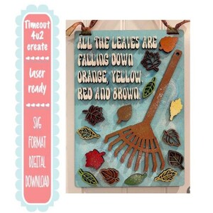 May include: A wooden sign with the text "All the leaves are falling down, orange, yellow, red and brown." The sign features a brown rake and colorful leaf cutouts. The background is light blue.
