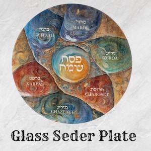 May include: A circular glass Seder plate with a vibrant, artistic design. The plate is divided into sections, each labeled with Hebrew and English text, such as "Maror," "Zeroa," and "Chazeret." The central text reads "Pesach Sameach."