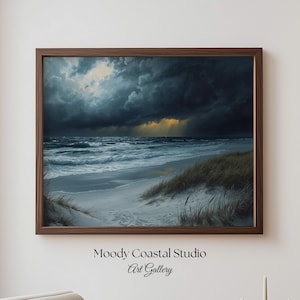May include: A framed art print depicting a stormy coastal scene. Dark, dramatic clouds loom over the ocean, with waves crashing on a sandy beach. The artwork features a moody color palette of blues, grays, and hints of yellow. The frame is a warm brown color. Text on the bottom reads "Moody Coastal Studio Art Gallery."