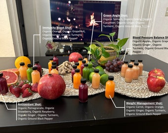 Peut inclure: Une table avec une variété de bouteilles en verre colorées remplies de jus différents. Chaque bouteille est étiquetée avec un avantage pour la santé différent, comme "Immunity Boost Shot", "Green Angle Shot", "Blood Pressure Balance Shot", "Antioxidant Shot" et "Weight Management Shot". Les bouteilles sont disposées en cercle sur une surface brune avec divers fruits et légumes autour.