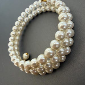 May include: A set of three ceramic vases in varying heights. The vases are white with a textured, ribbed design. The tallest vase is approximately 10 inches tall, the medium vase is 8 inches, and the smallest is 6 inches.