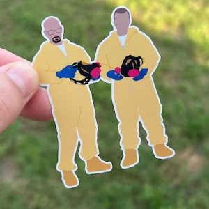 May include: Two figures wearing yellow jumpsuits and blue gloves, holding black gas masks with pink filters. The figures are standing side-by-side.