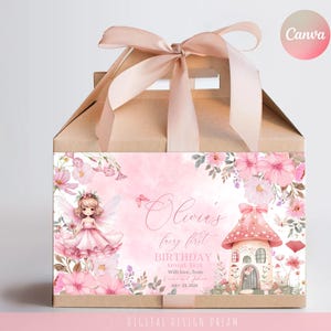 May include: A light brown gift box with a pink ribbon bow. The front of the box features a pink watercolor design with a fairy, flowers, and the text "Olivia's fairy first birthday".